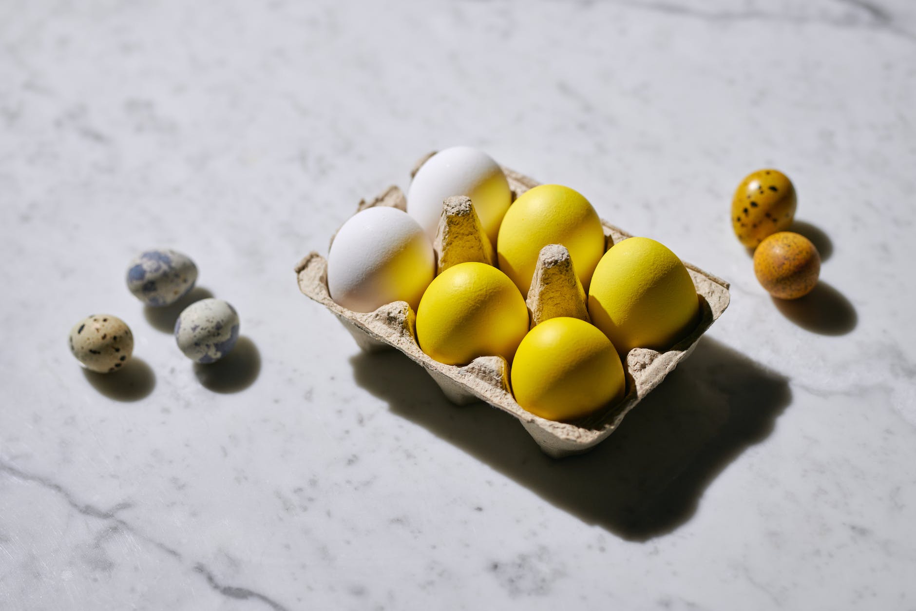 yellow eggs on a tray near quail eggs